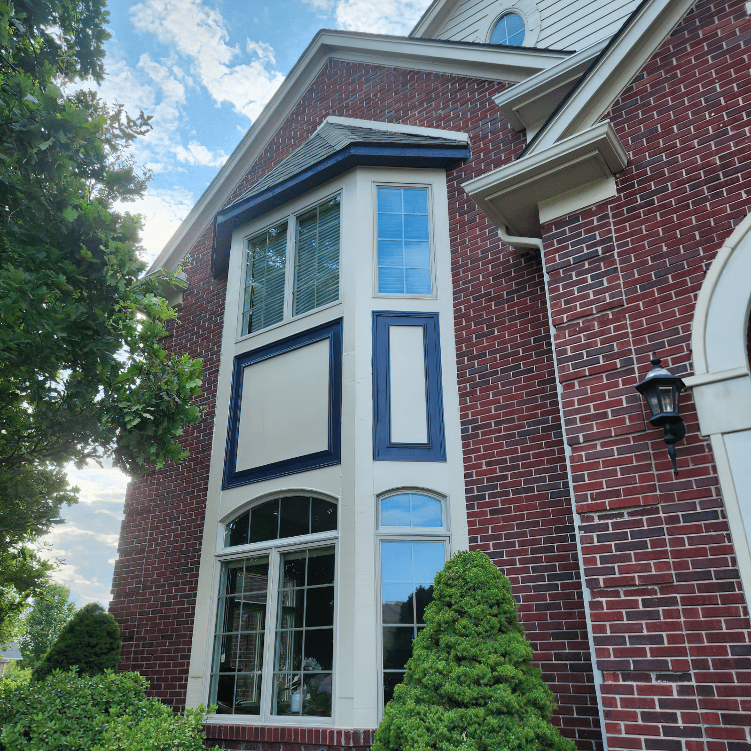front part of a house with window front with its sidings painted white and blue accent